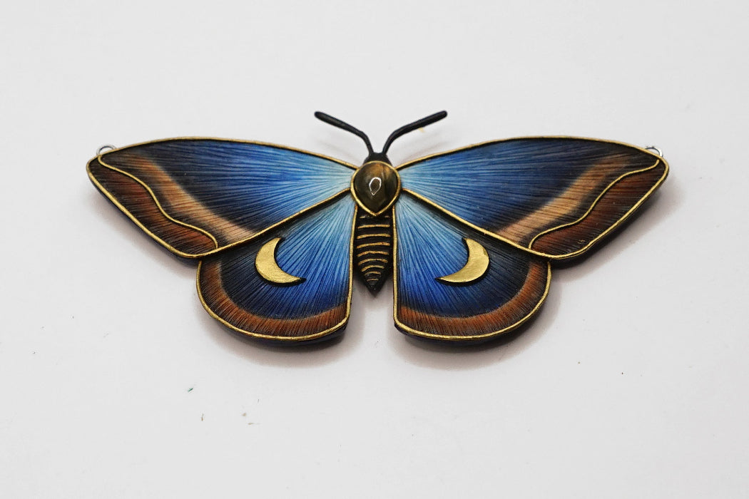 Decorative butterfly with blue wings and gold accents on a white background