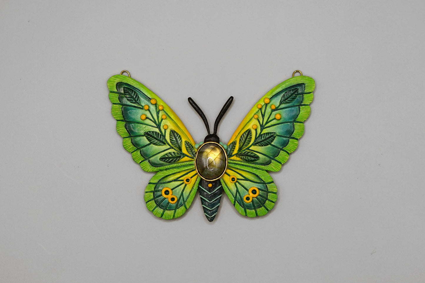 Green butterfly-shaped decorative item on a gray background