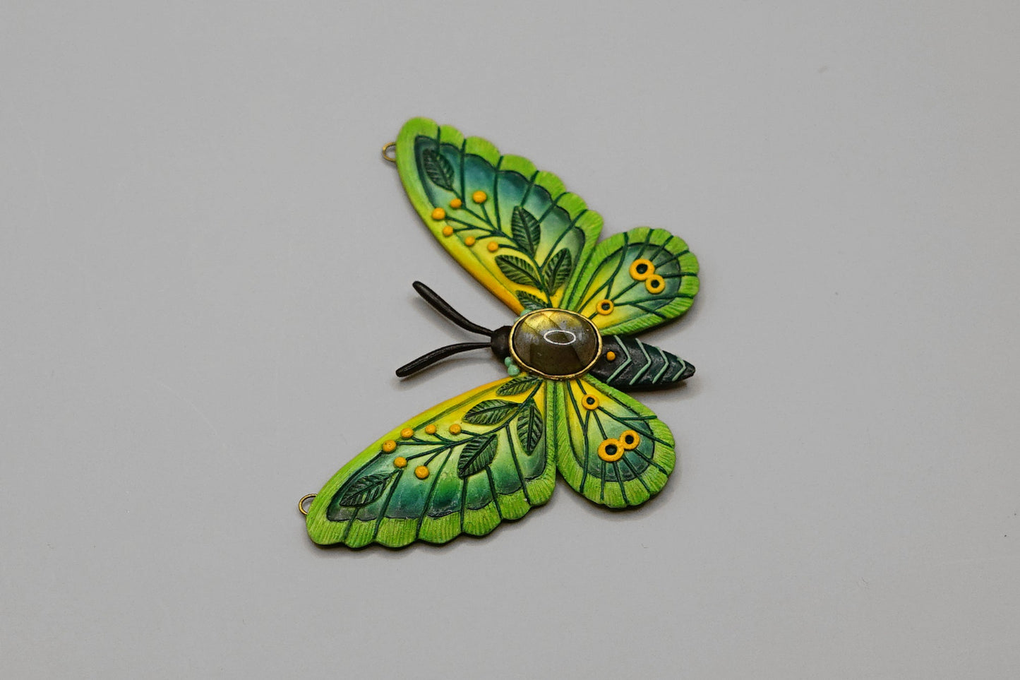 Green butterfly-shaped object on a gray background