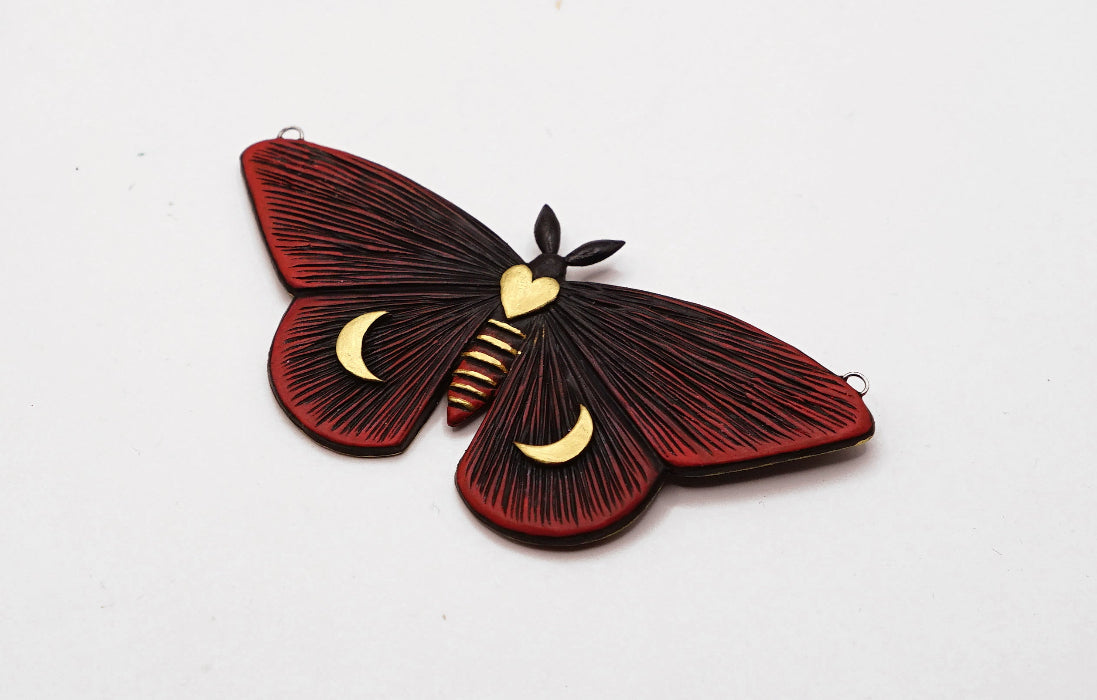 Decorative butterfly with red and black wings on a white background