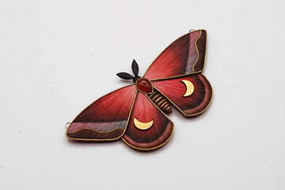 Red and gold butterfly-shaped pendant on a white background