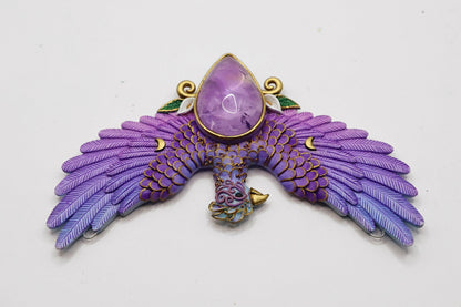 Purple phoenix pendant with a central gemstone on a white background