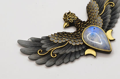 Decorative bird-shaped pendant with gold and black details on a white background