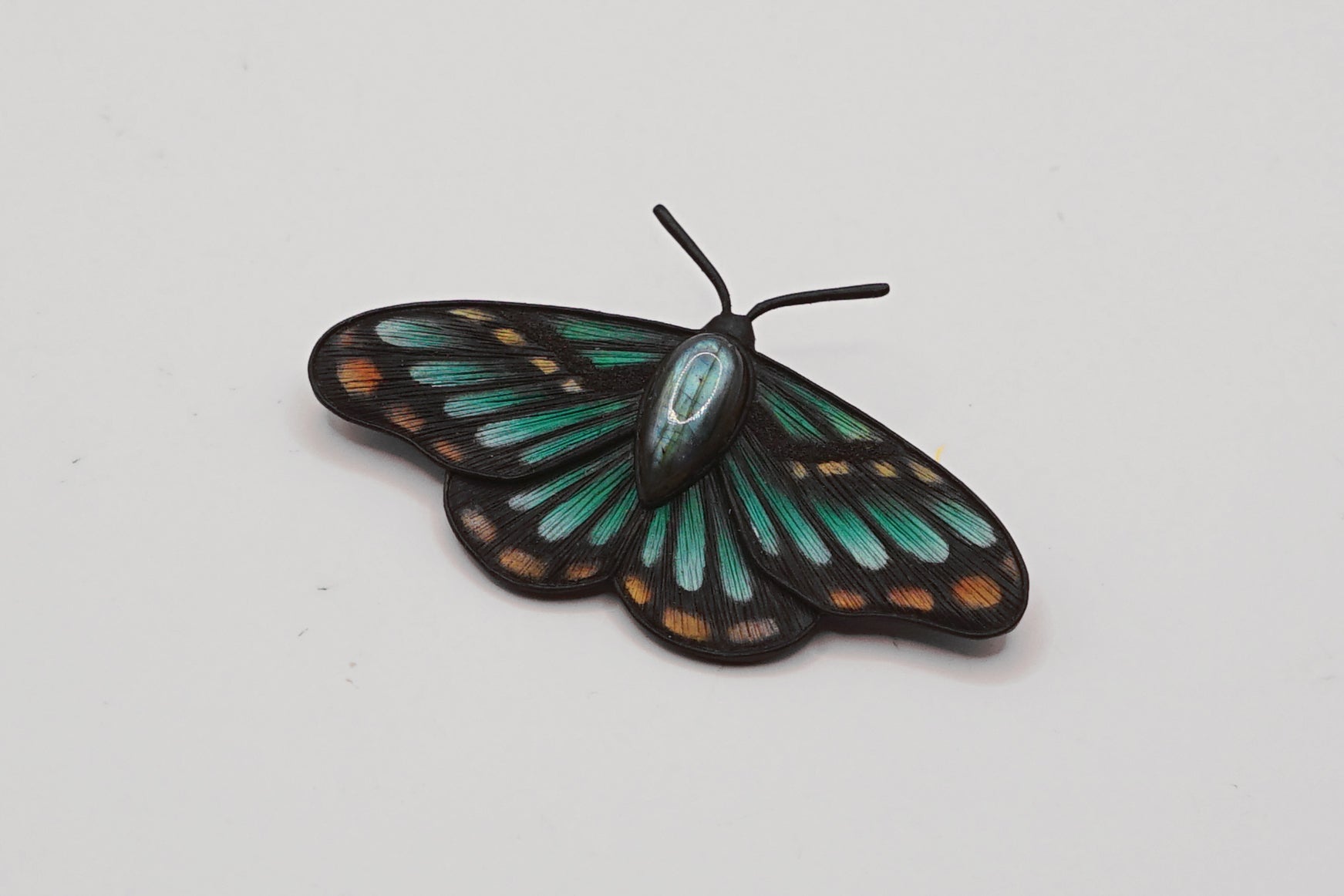 Butterfly-shaped object with green and black colors on a white background