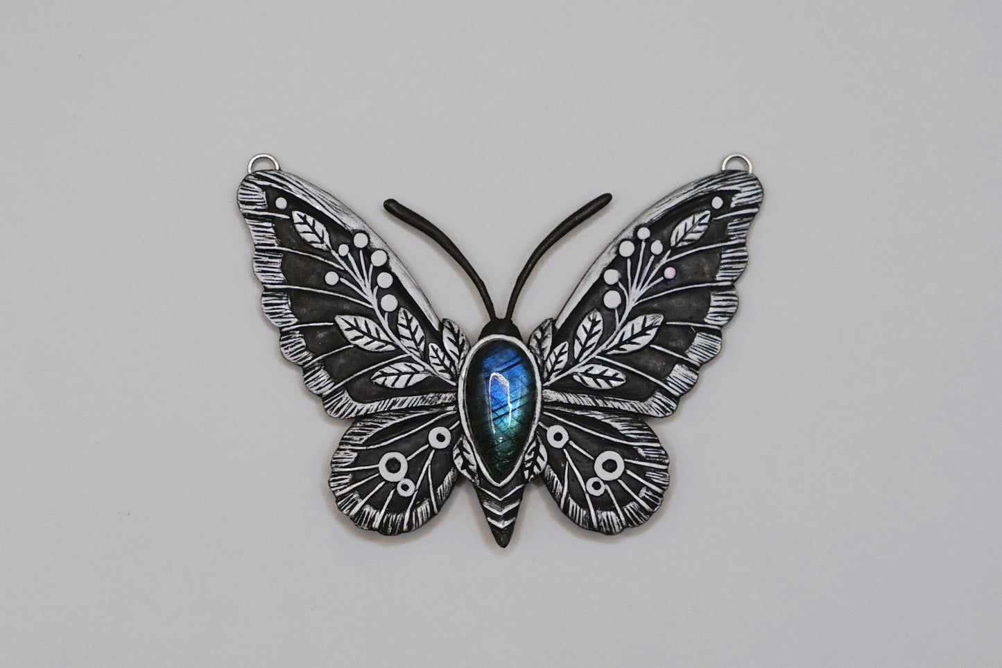 Butterfly-shaped object with intricate design on a gray background