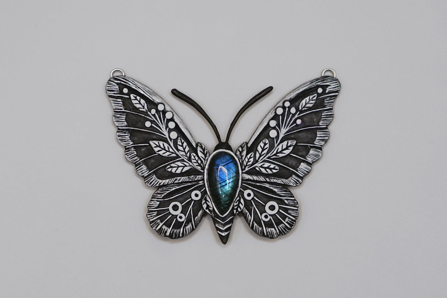Butterfly-shaped object with intricate design on a gray background