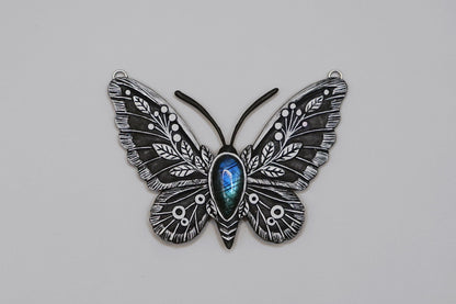 Butterfly-shaped object with intricate design on a gray background