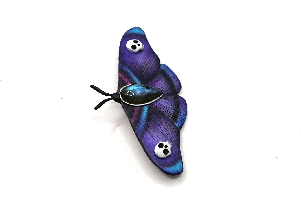 Purple butterfly-shaped object on a white background