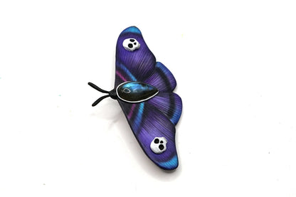 Purple butterfly-shaped object on a white background